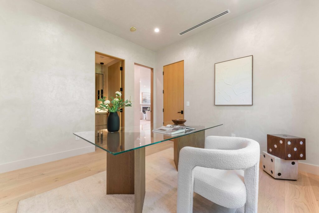 Professional stager adjusting artwork and furniture alignment in bright interior