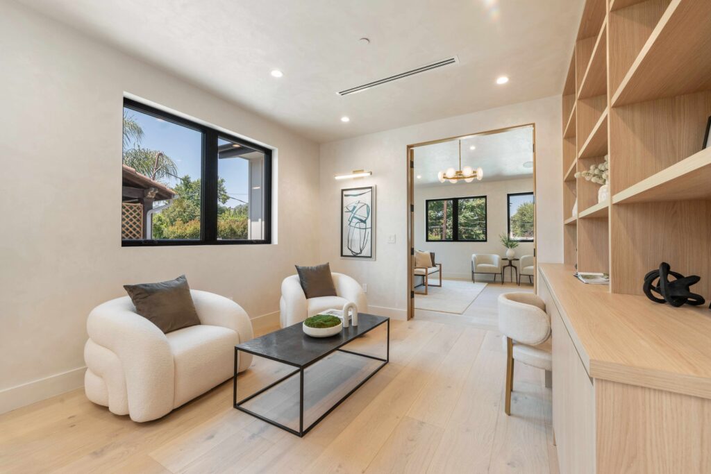 Designer reviewing custom sofa dimensions for a bright Ventura living room installation