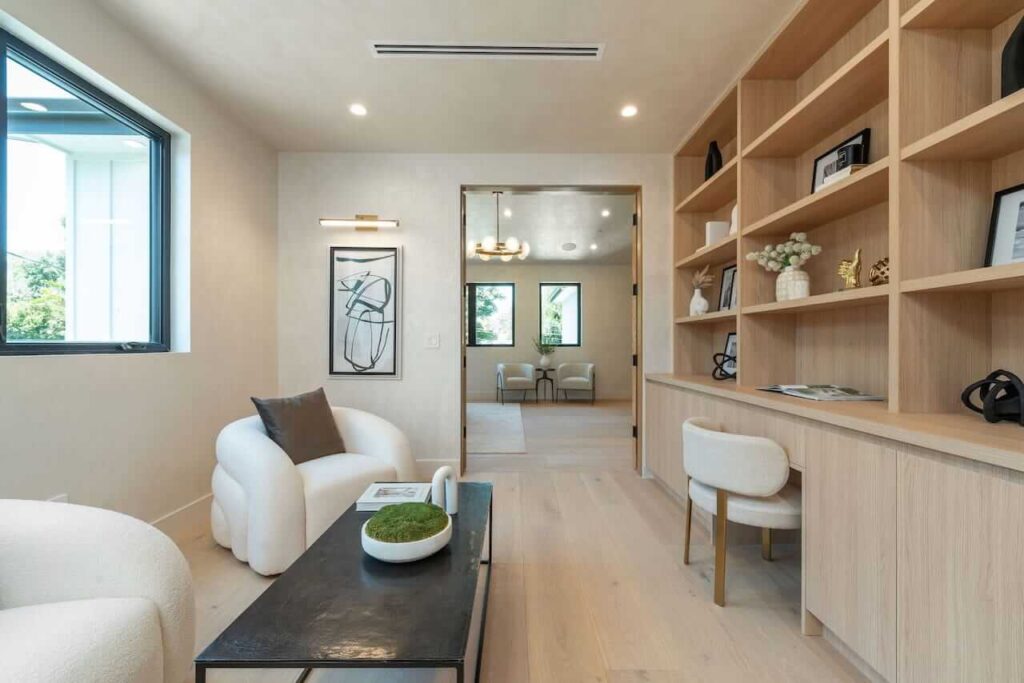 Professional stager refining upscale furniture layout in bright coastal home interior
